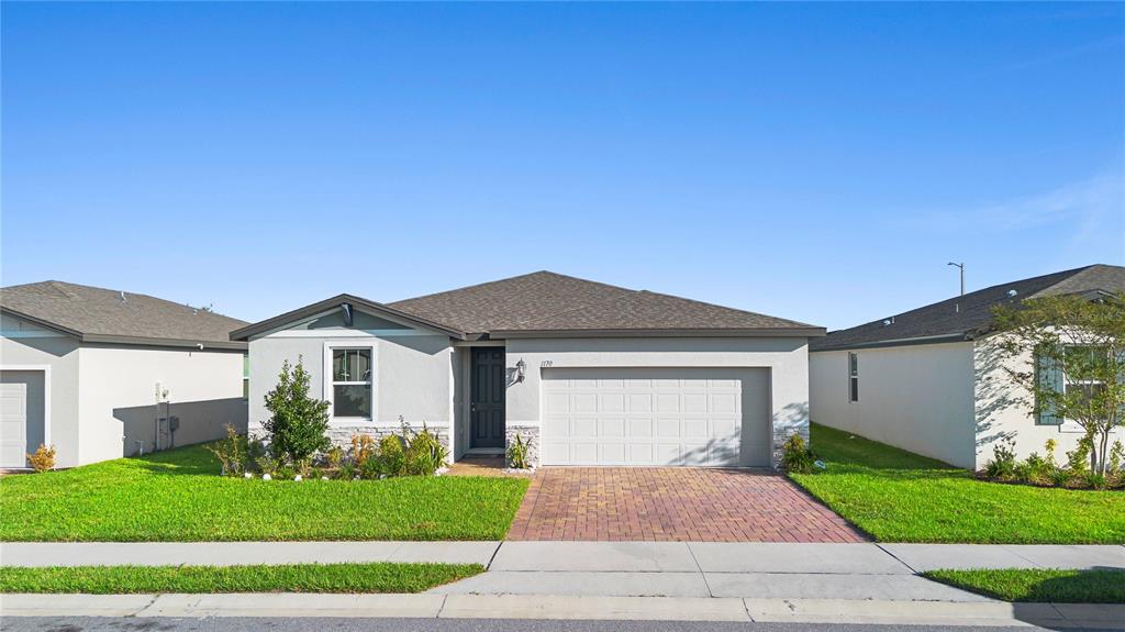 a front view of a house with a yard and garage