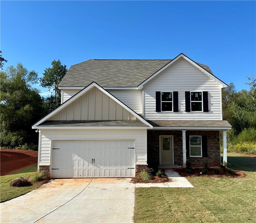 a front view of a house with yard and garage