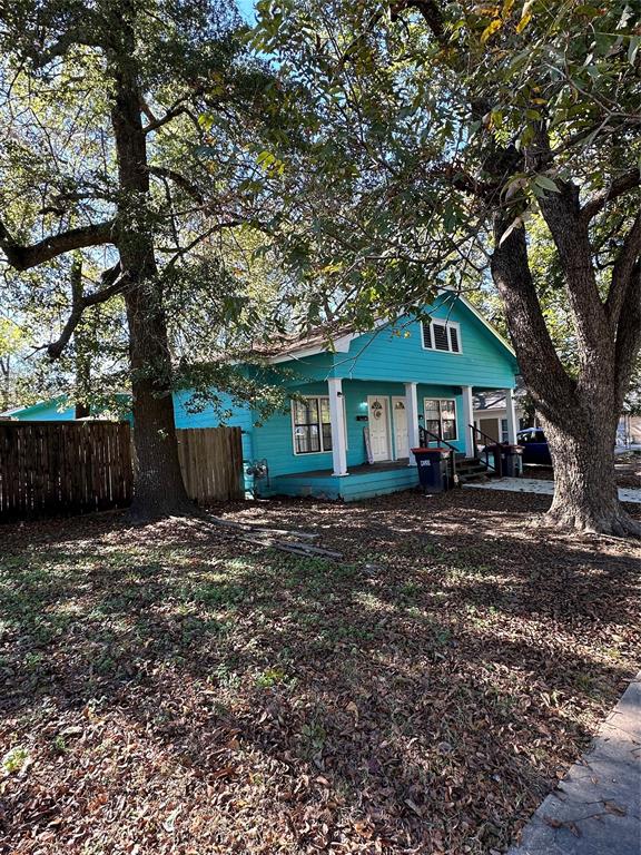 a front view of a house with yard tree and wooden fence