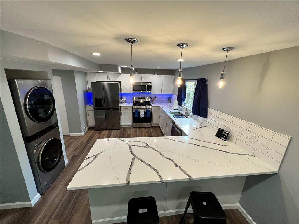 a view of a kitchen with a sink a washer and dryer