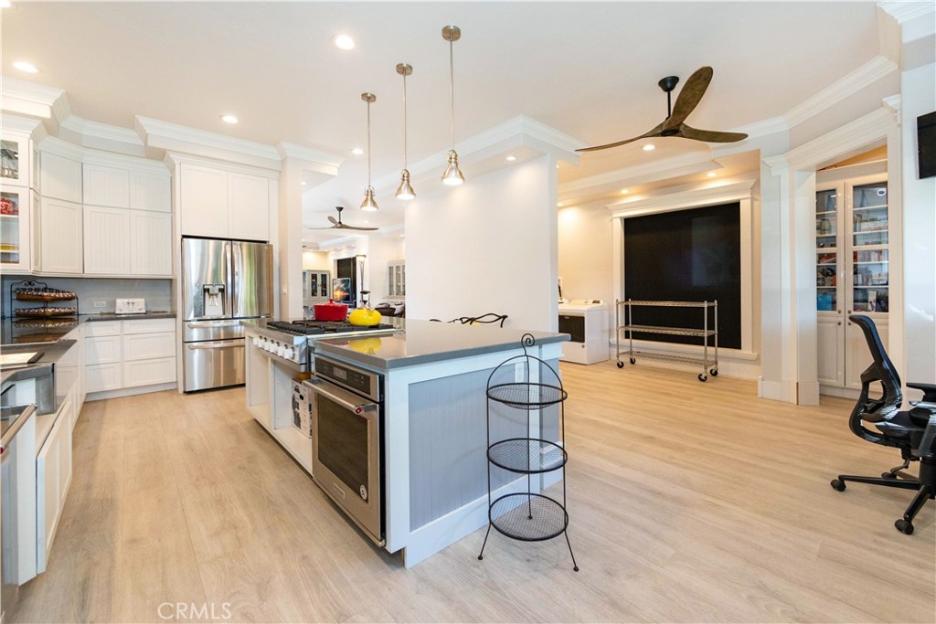 a kitchen with stainless steel appliances kitchen island granite countertop a stove and a refrigerator with wooden floor