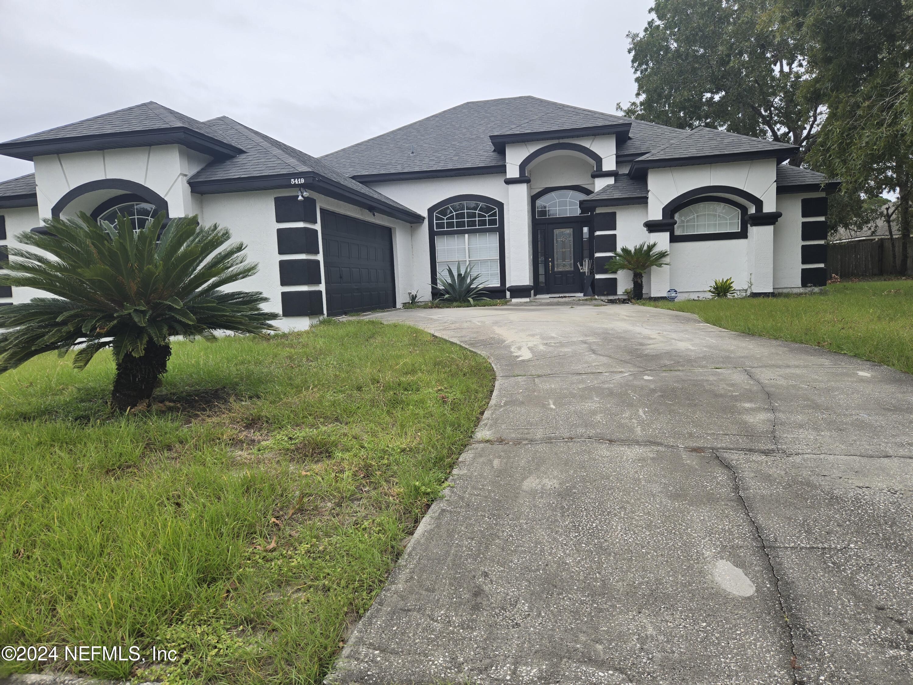 a front view of a house with a garden