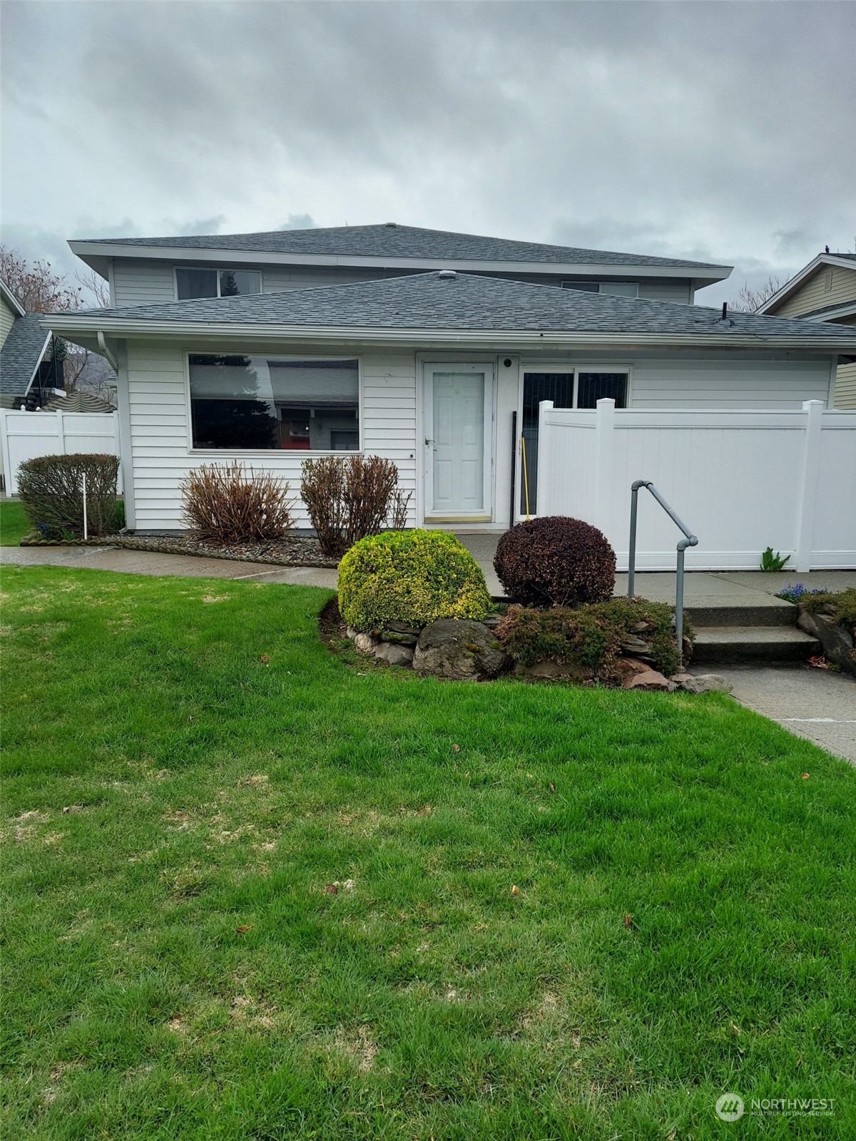 a front view of a house with a garden and plants