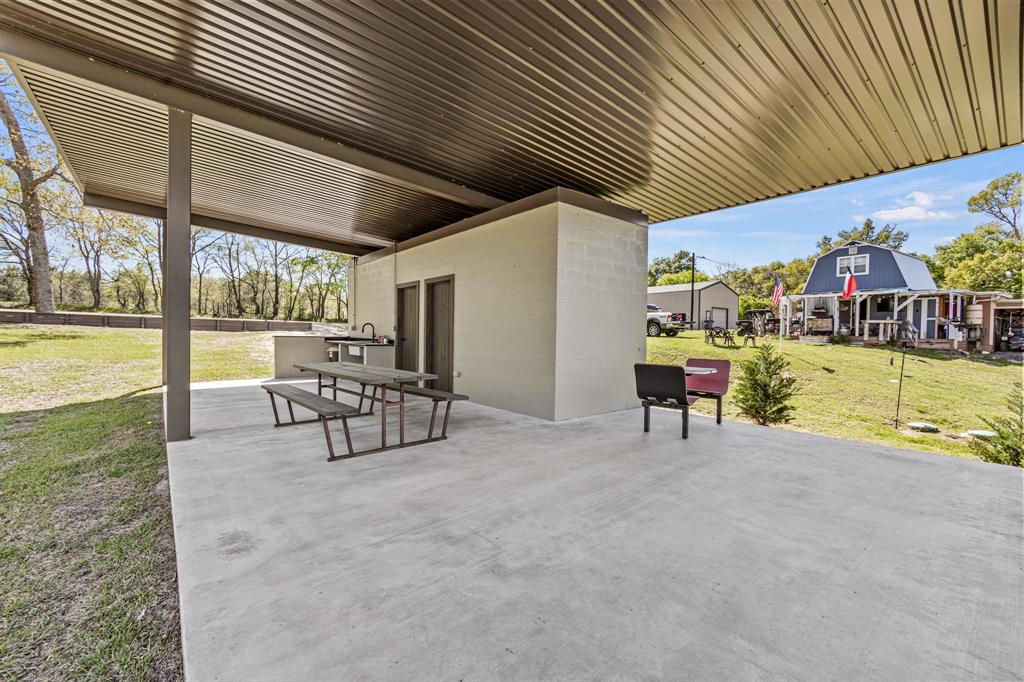 a view of a patio with table and chairs with wooden floor and fence