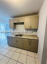 a kitchen with granite countertop a sink a stove a oven and cabinets