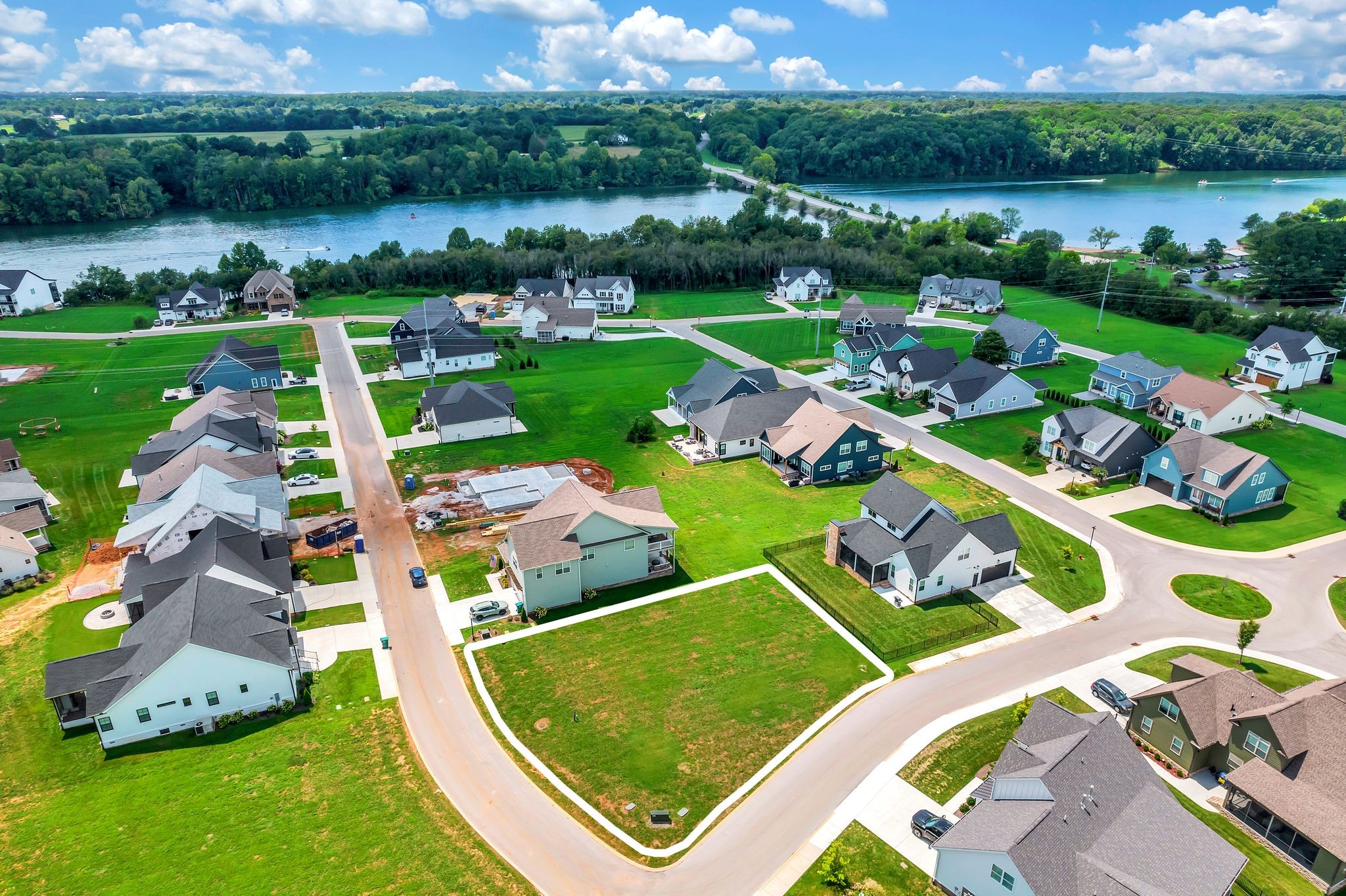 an aerial view of a house with outdoor space lake view and large trees all around