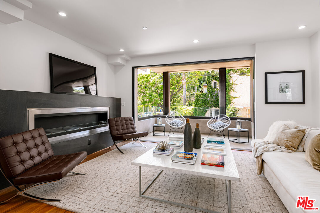 a living room with furniture fireplace and a large window