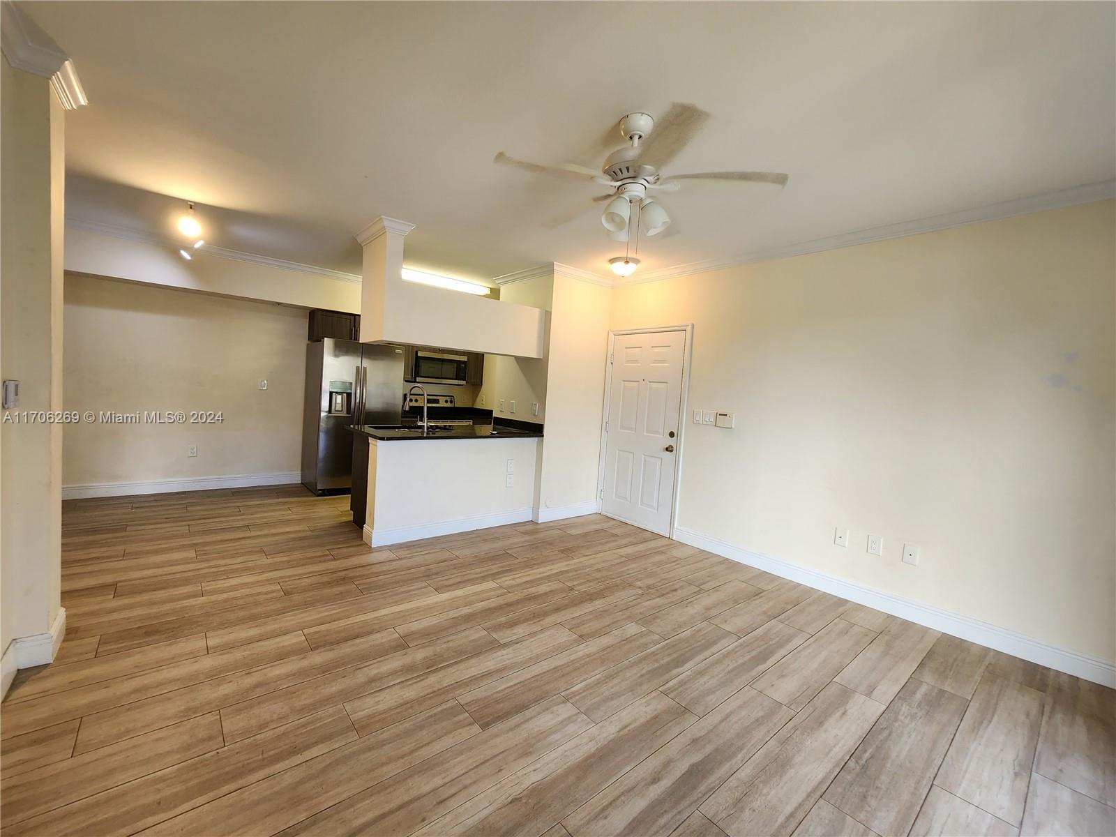 a view of a kitchen with a sink and a refrigerator