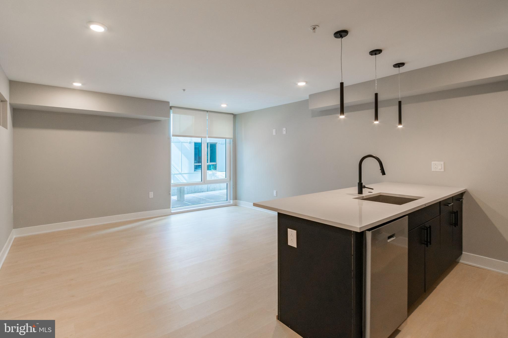 a kitchen with a sink and wooden floor