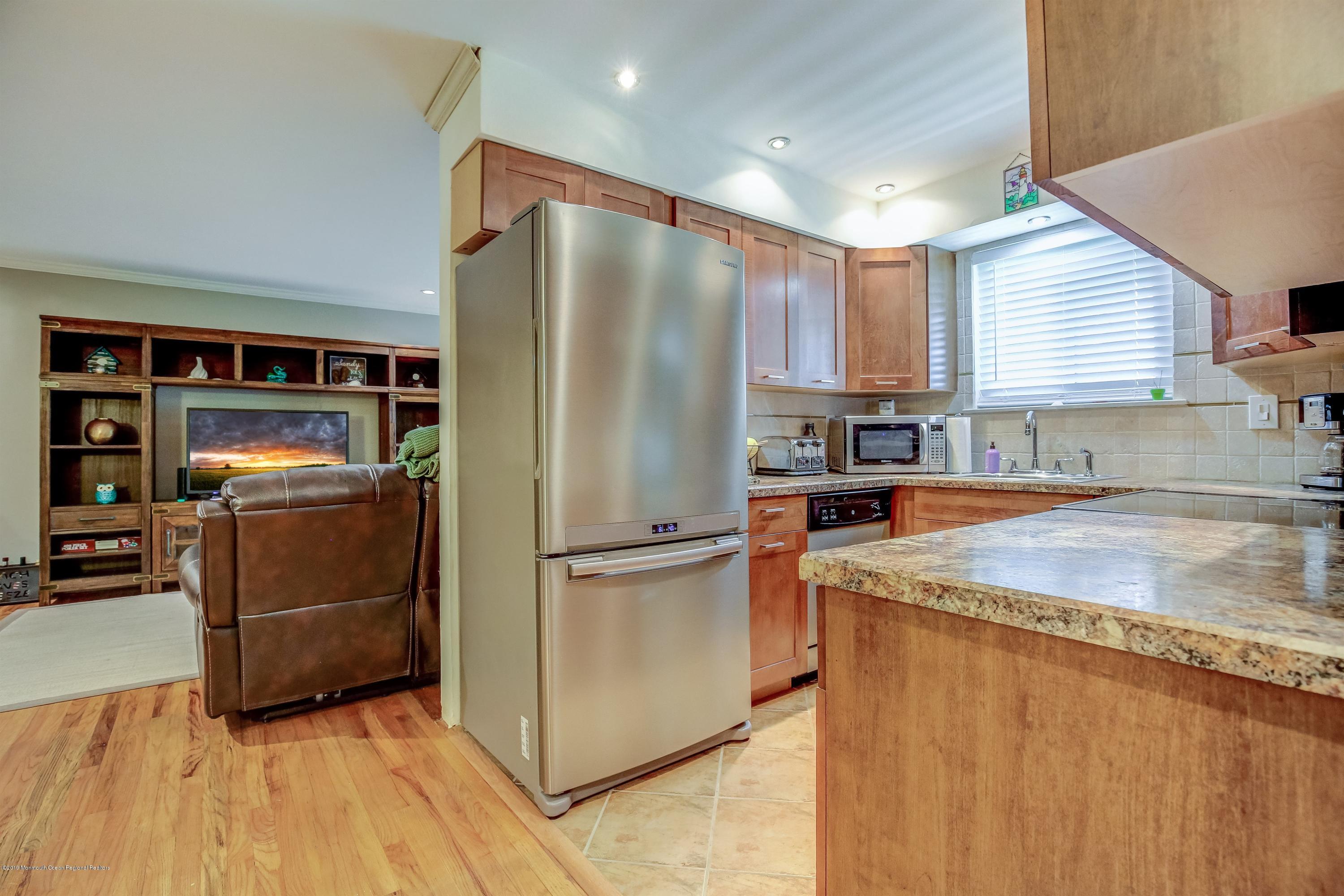 a kitchen with stainless steel appliances granite countertop a refrigerator a sink and a stove