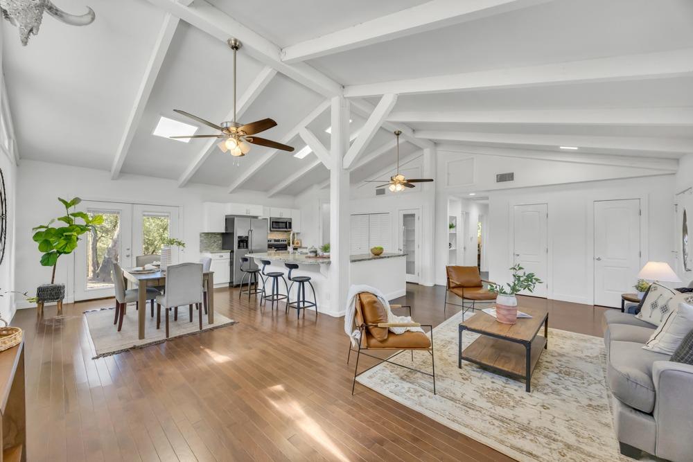 a living room with lots of furniture wooden floor and a chandelier