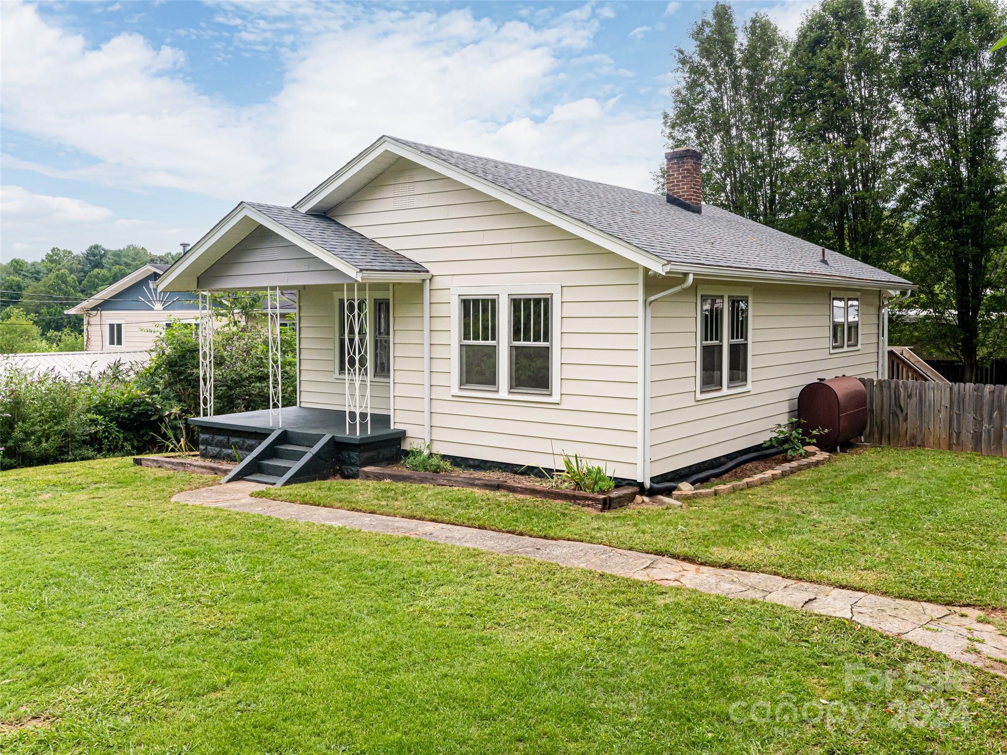 a view of a house with a patio and a yard