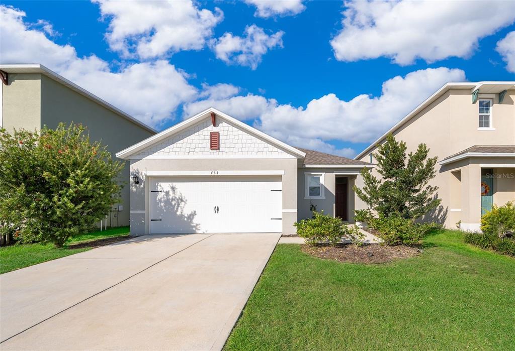 a front view of a house with a yard and garage