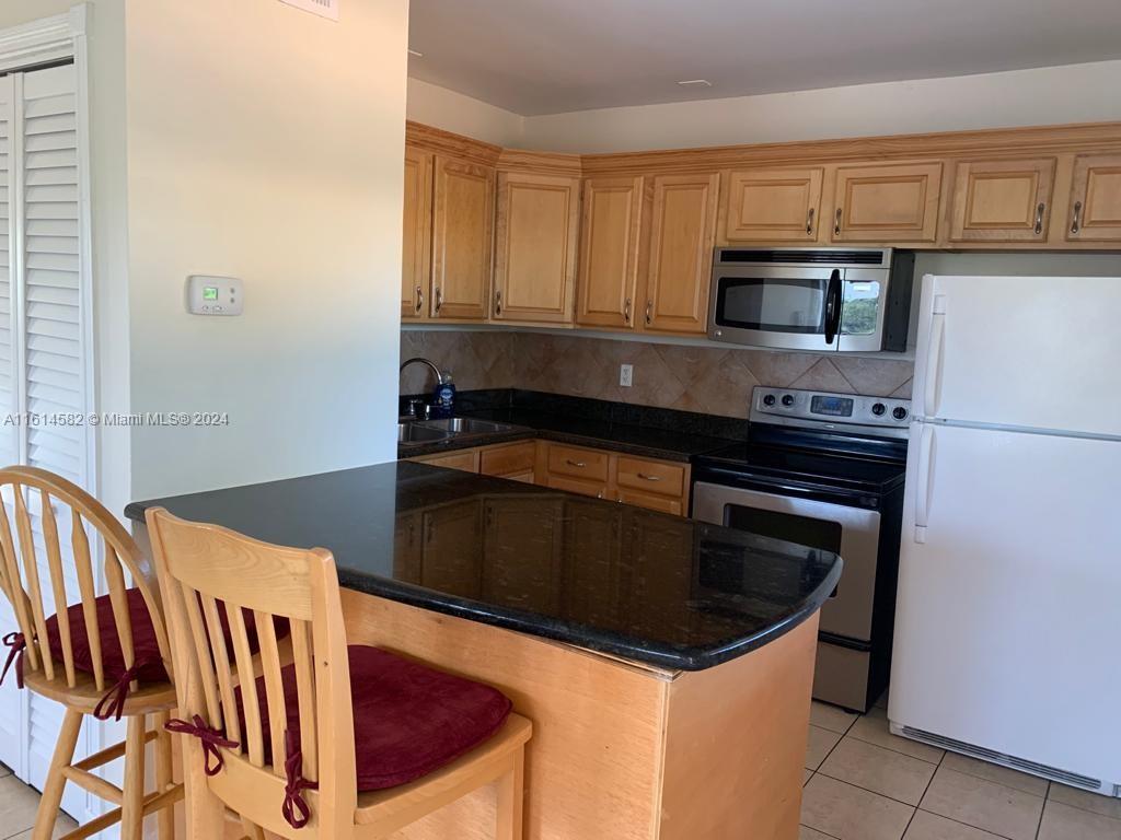 a kitchen with granite countertop a stove and a sink