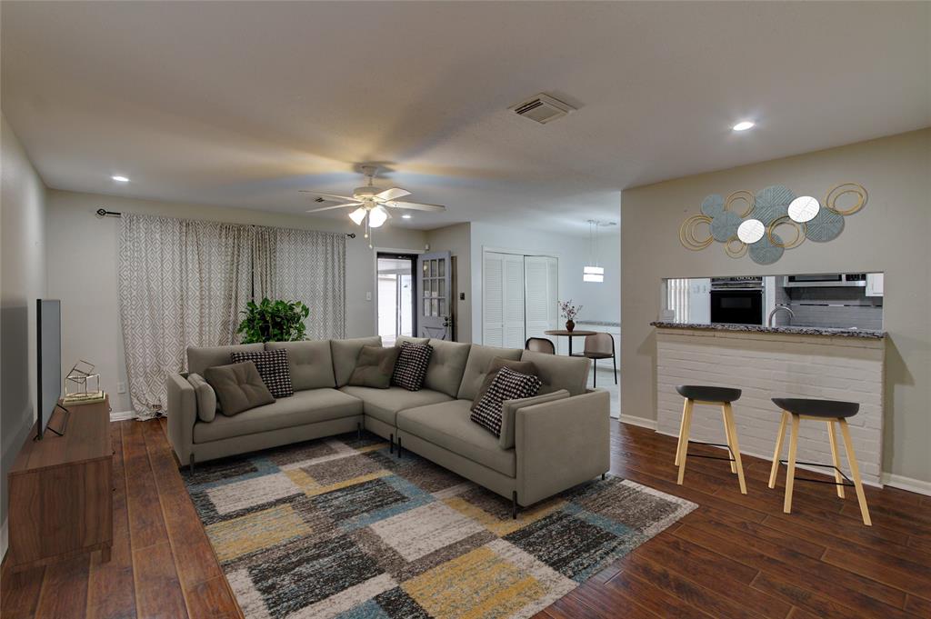 a living room with furniture and a wooden floor