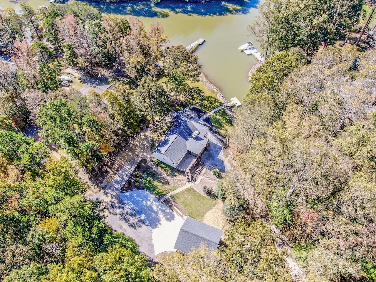 an aerial view of a house with a yard and lake view