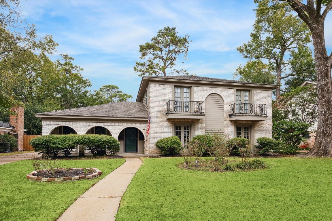 a front view of a house with a garden and plants