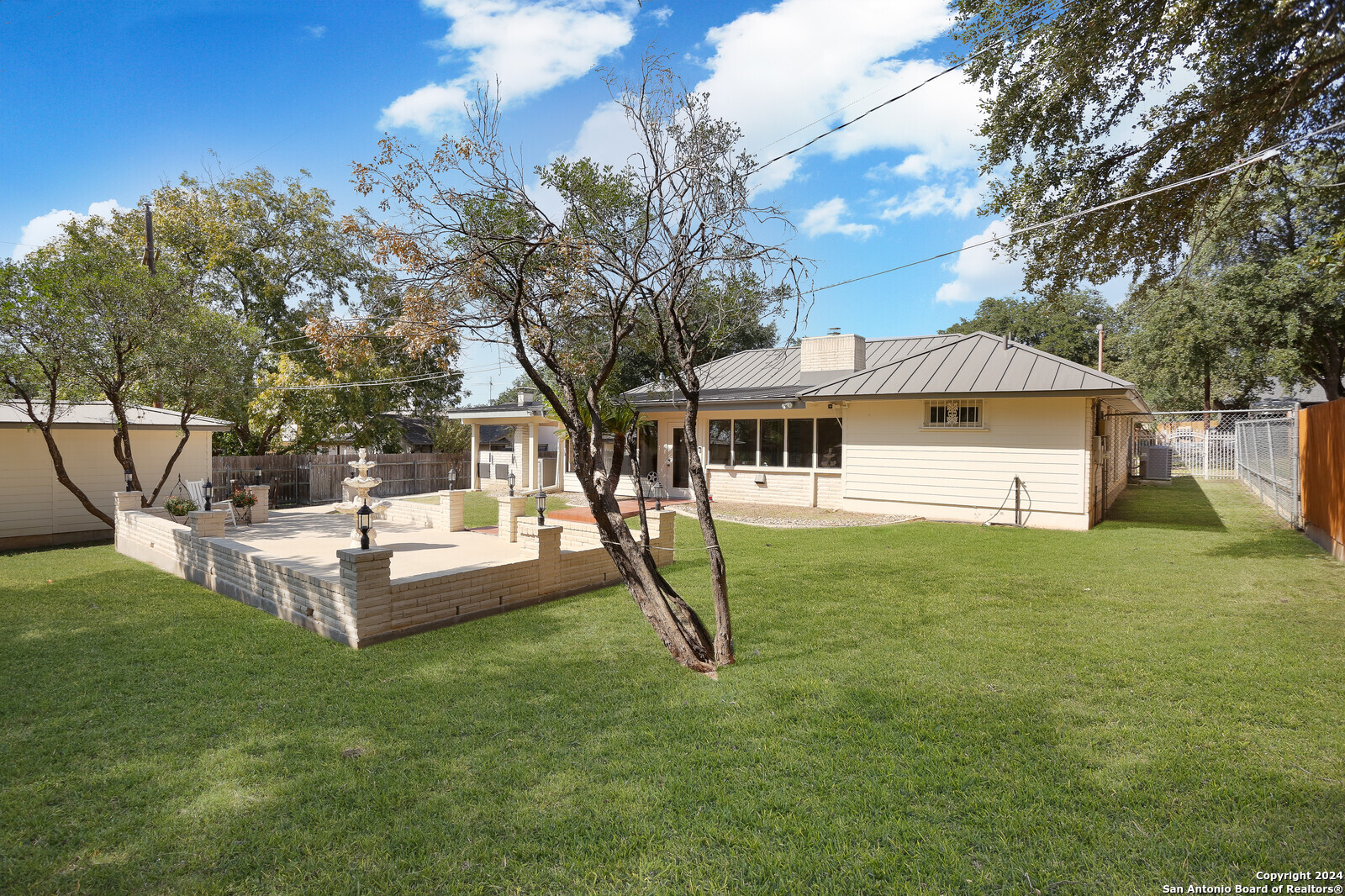 a view of a house with backyard and a tree