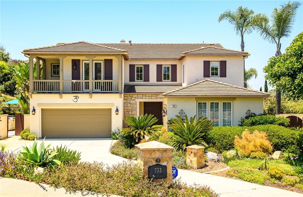 a front view of a house with a yard and potted plants