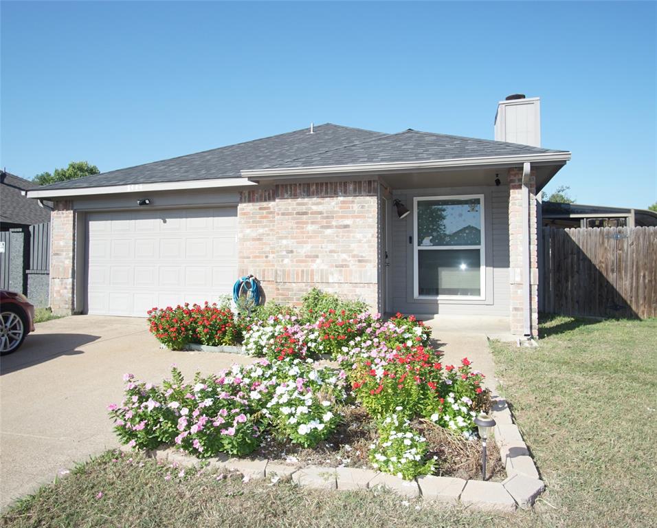 a front view of a house with a yard and a garden