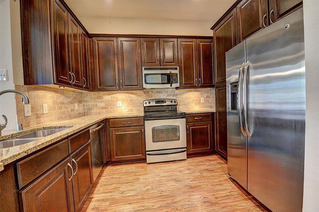 a kitchen with granite countertop stainless steel appliances and wooden cabinets