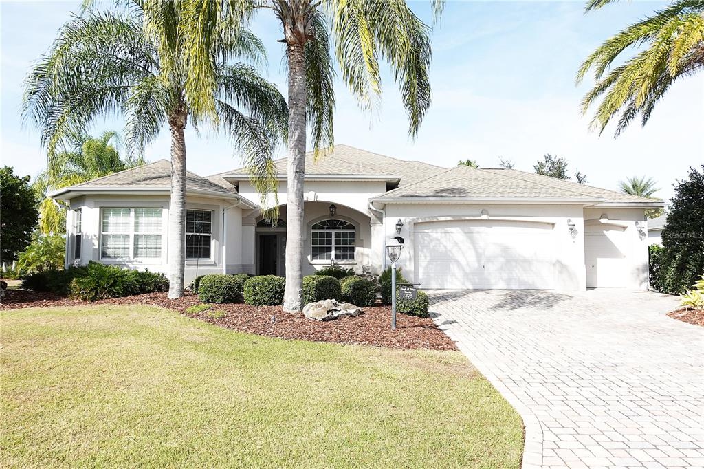 a view of a house with a yard and palm trees