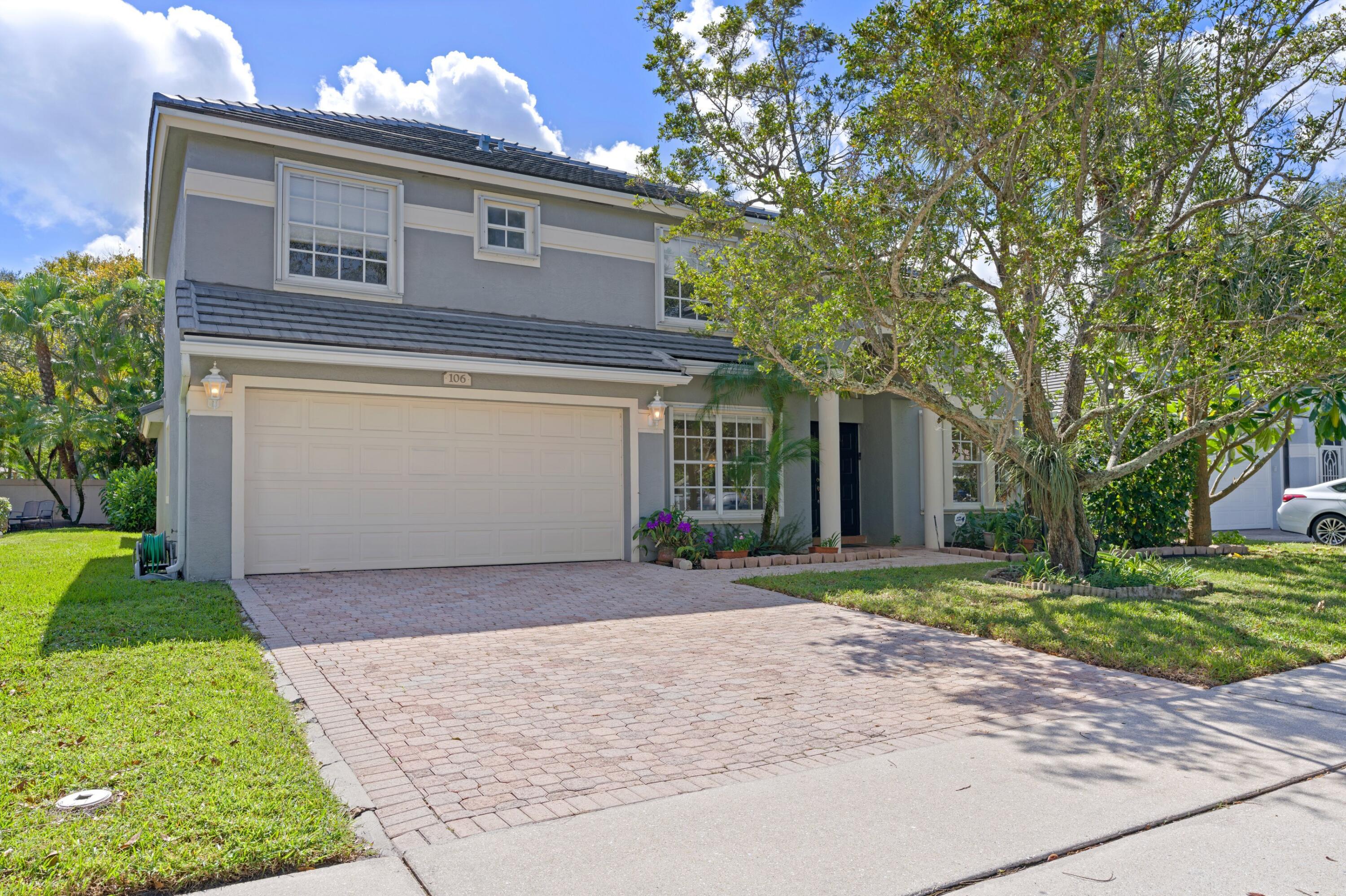 a front view of a house with a yard and garage