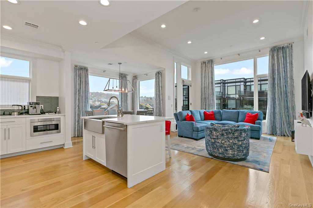 a living room with stainless steel appliances kitchen island granite countertop a stove and a refrigerator