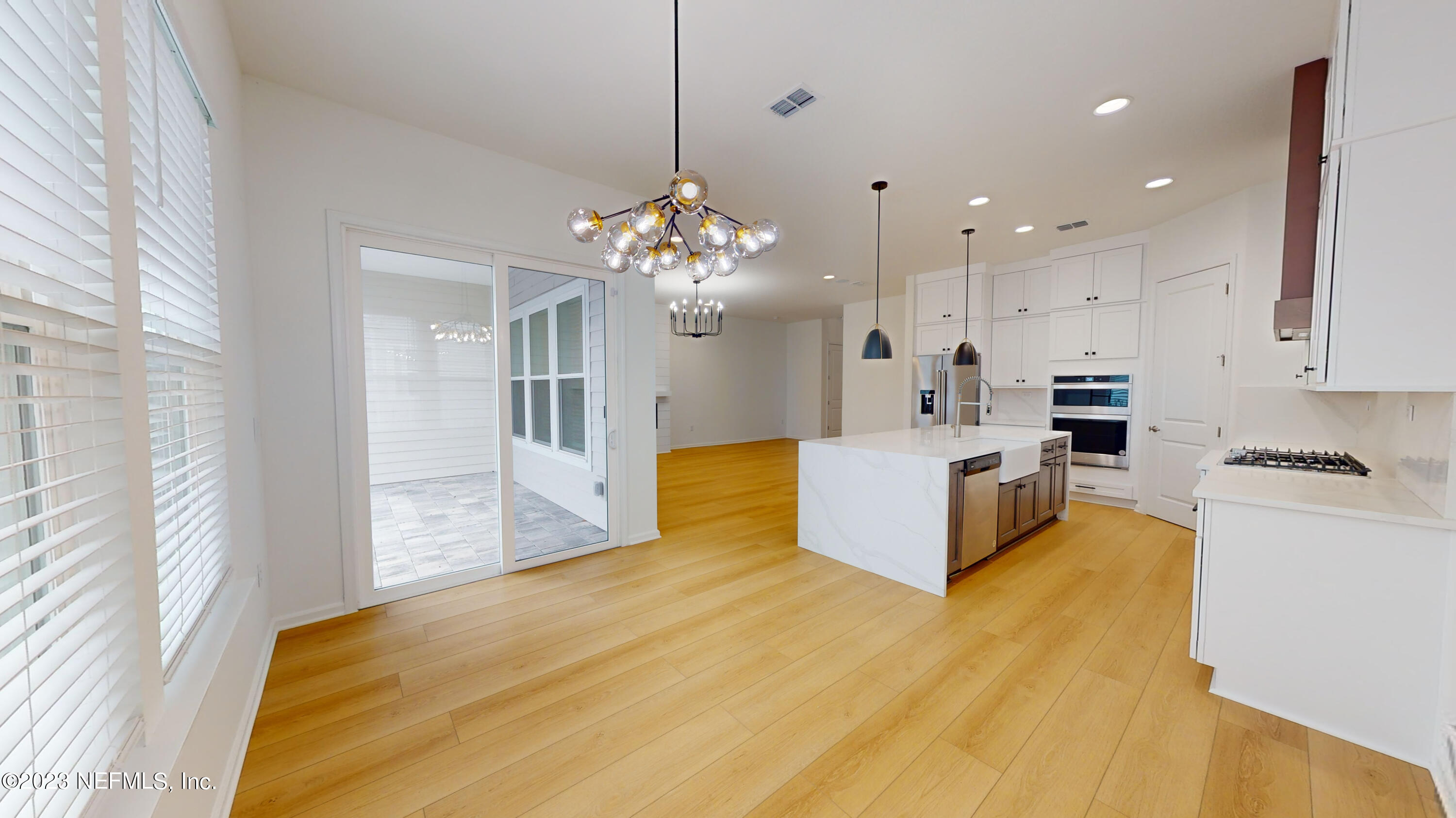 a large kitchen with kitchen island a stove a sink a center island and a chandelier