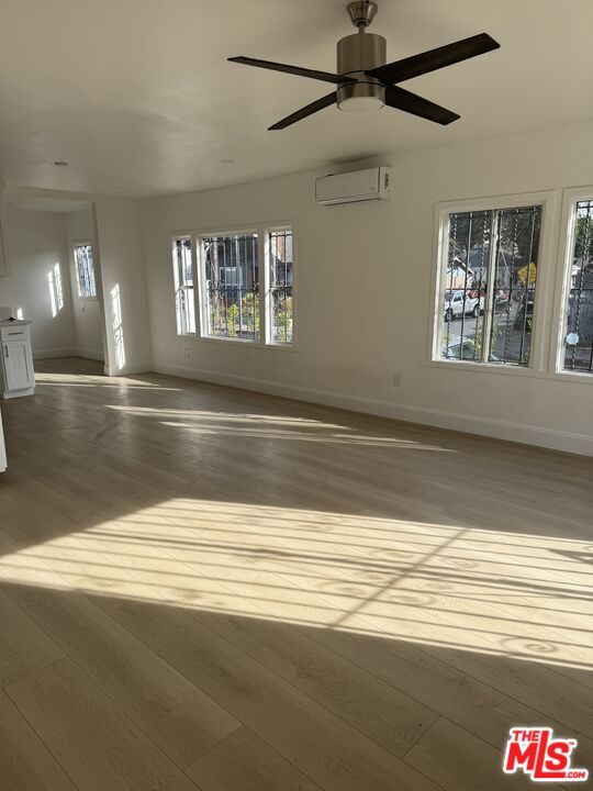 a view of empty room with window and wooden floor