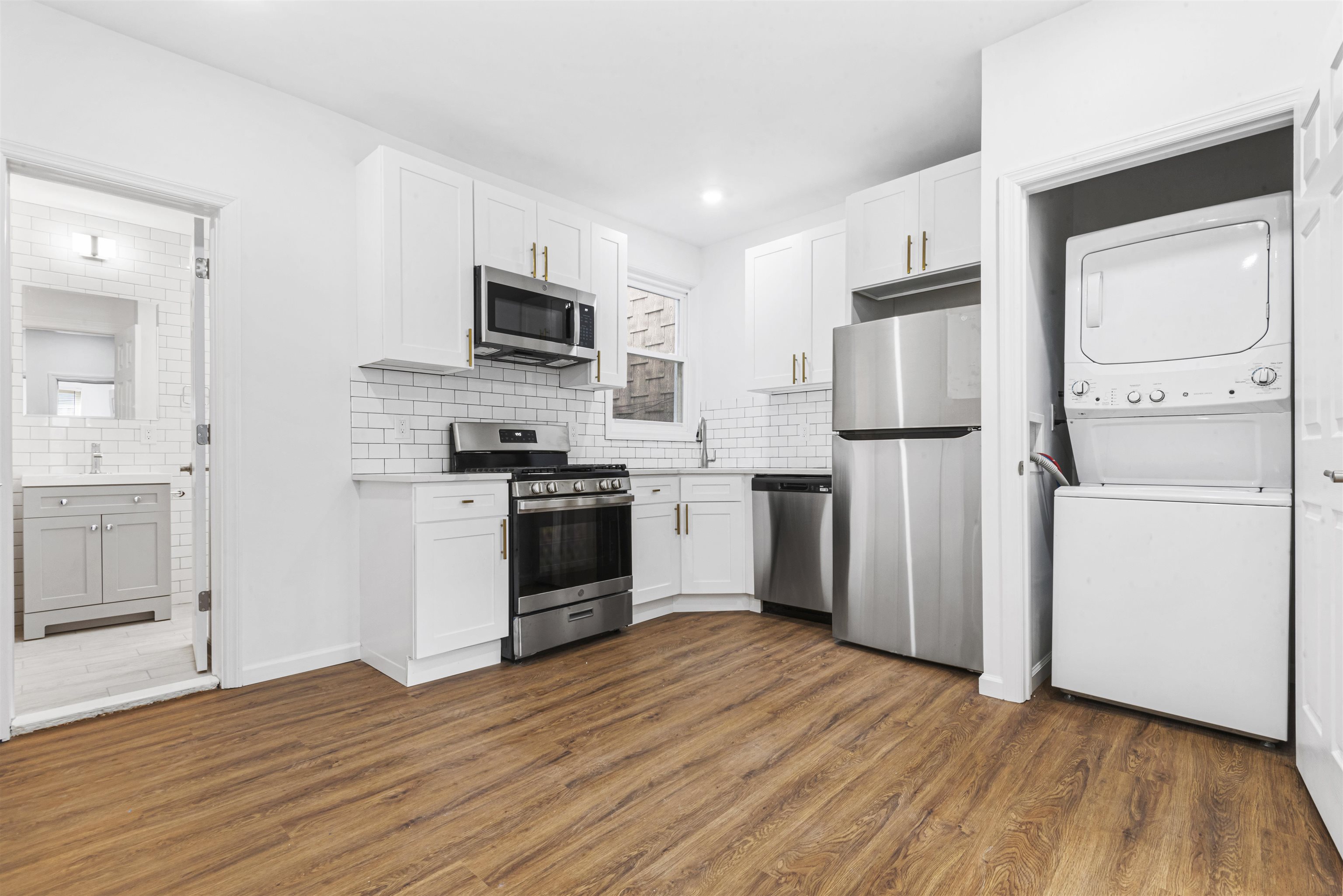 a kitchen with white cabinets and stainless steel appliances