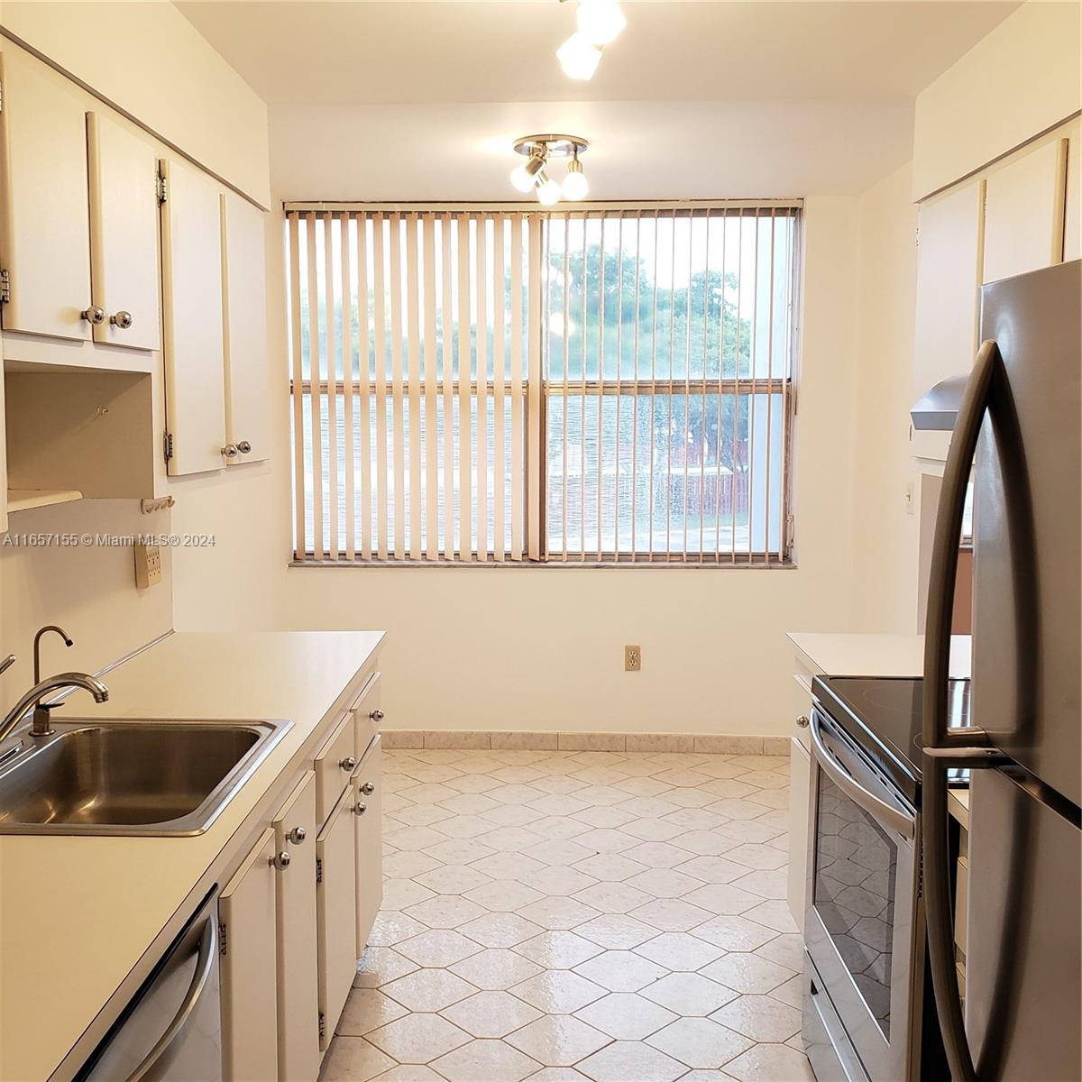 a kitchen with a sink a window and a refrigerator