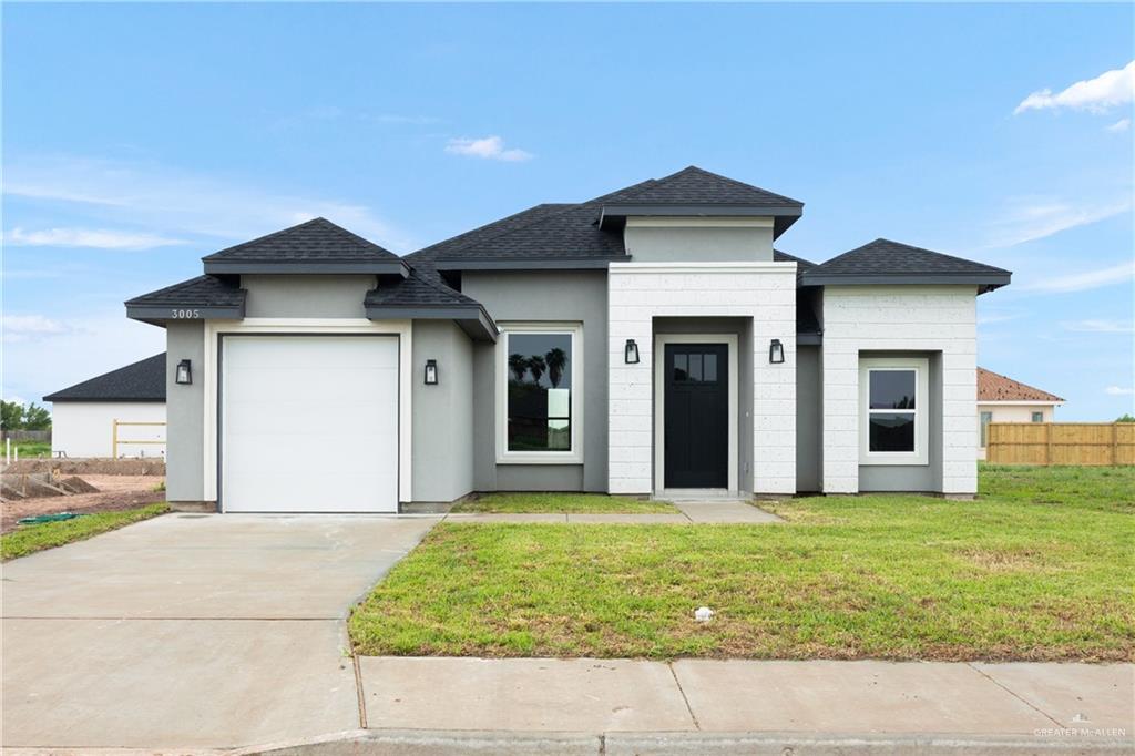 Prairie-style house featuring a front yard and a garage