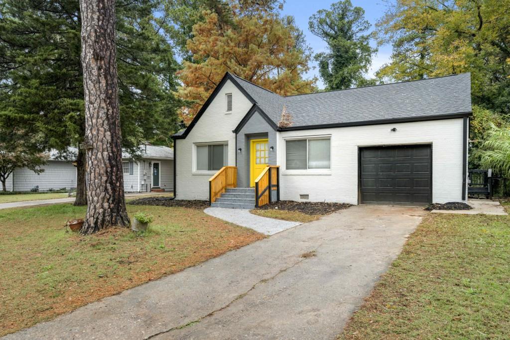 a view of a house with a yard and large tree