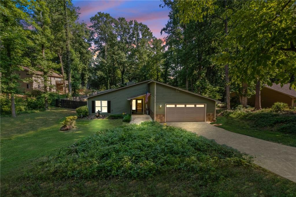 a front view of a house with a yard and trees