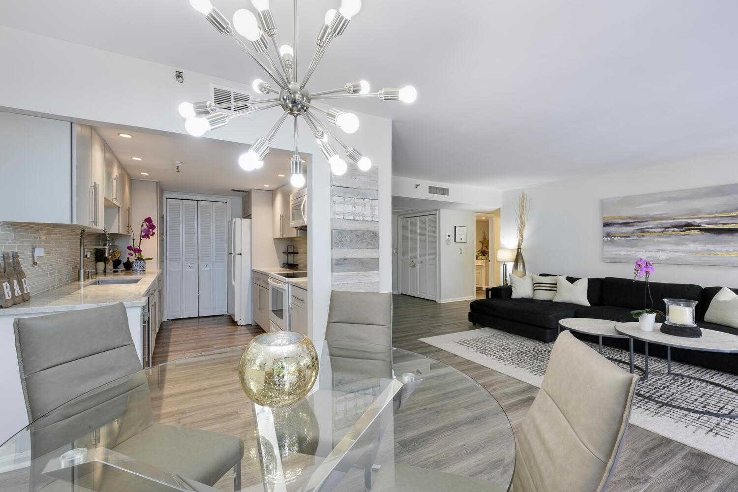 a living room with furniture a chandelier and a dining table