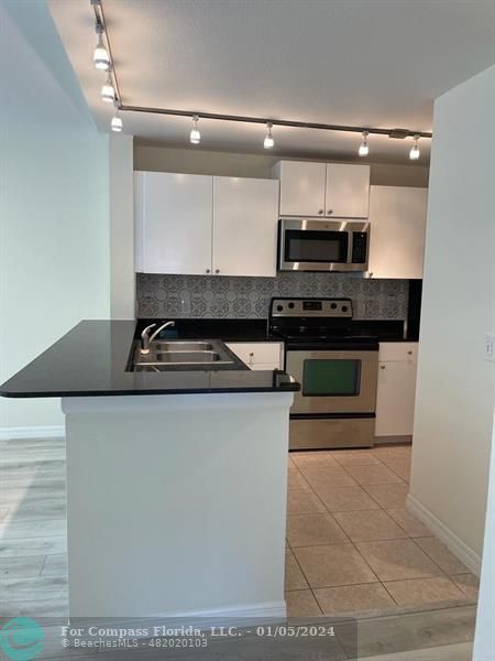 a kitchen with stainless steel appliances granite countertop a stove and a sink