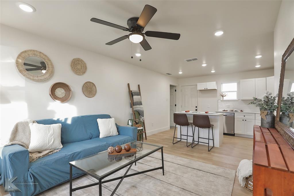 Living room with ceiling fan and light wood-type flooring