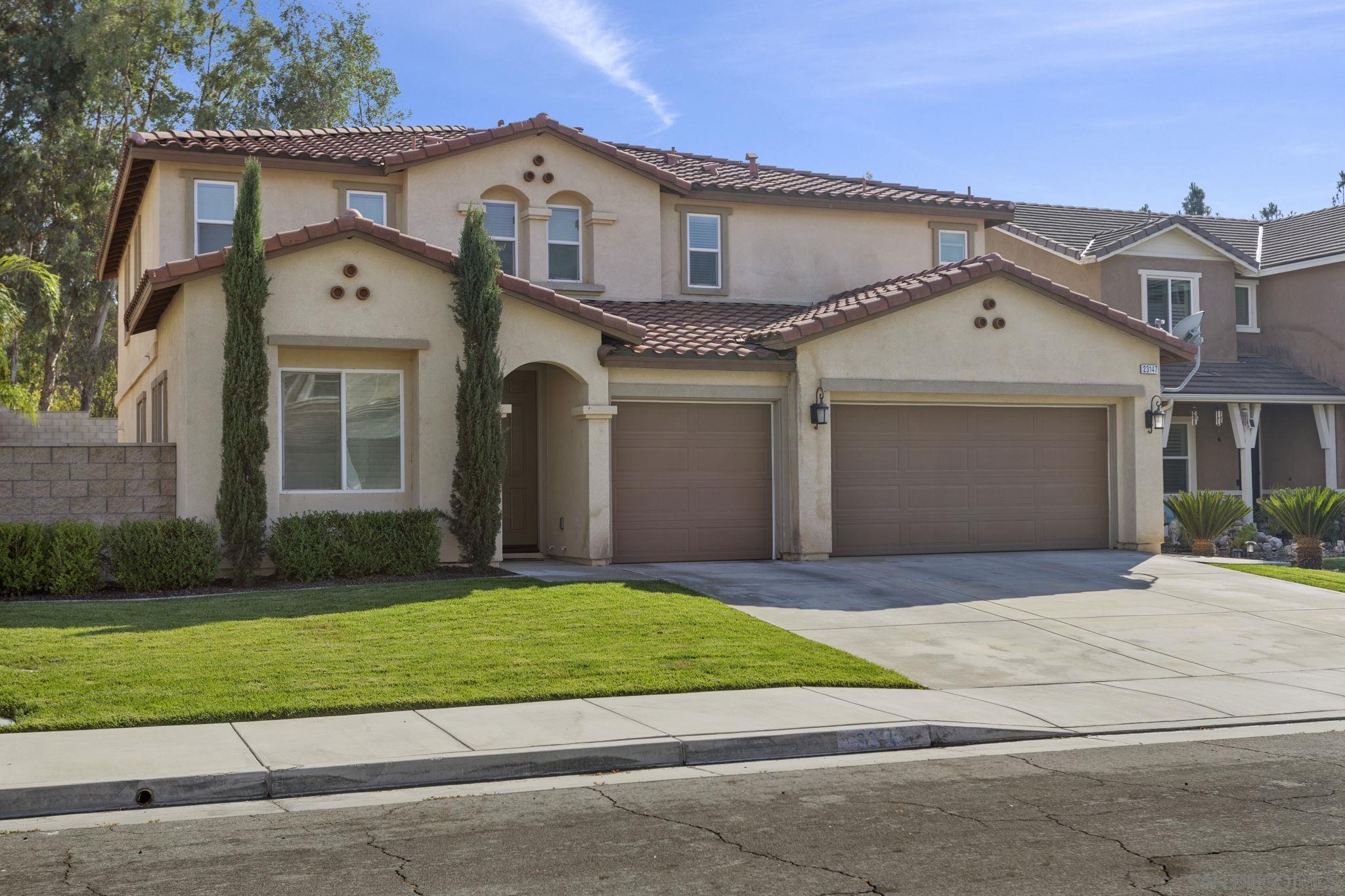 a front view of a house with a garden and yard