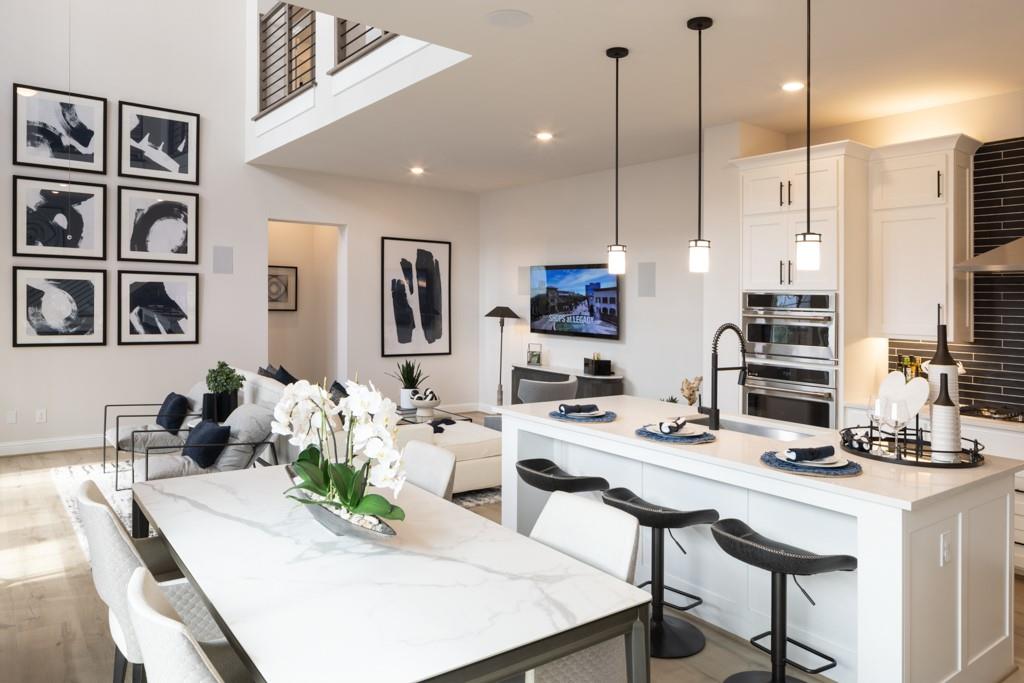 a kitchen with stainless steel appliances kitchen island granite countertop a table chairs and a refrigerator