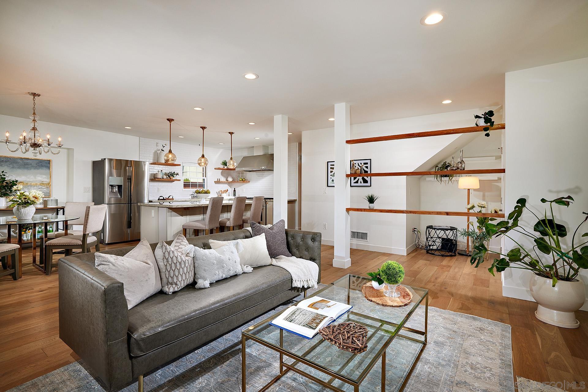 a living room with furniture and a kitchen view