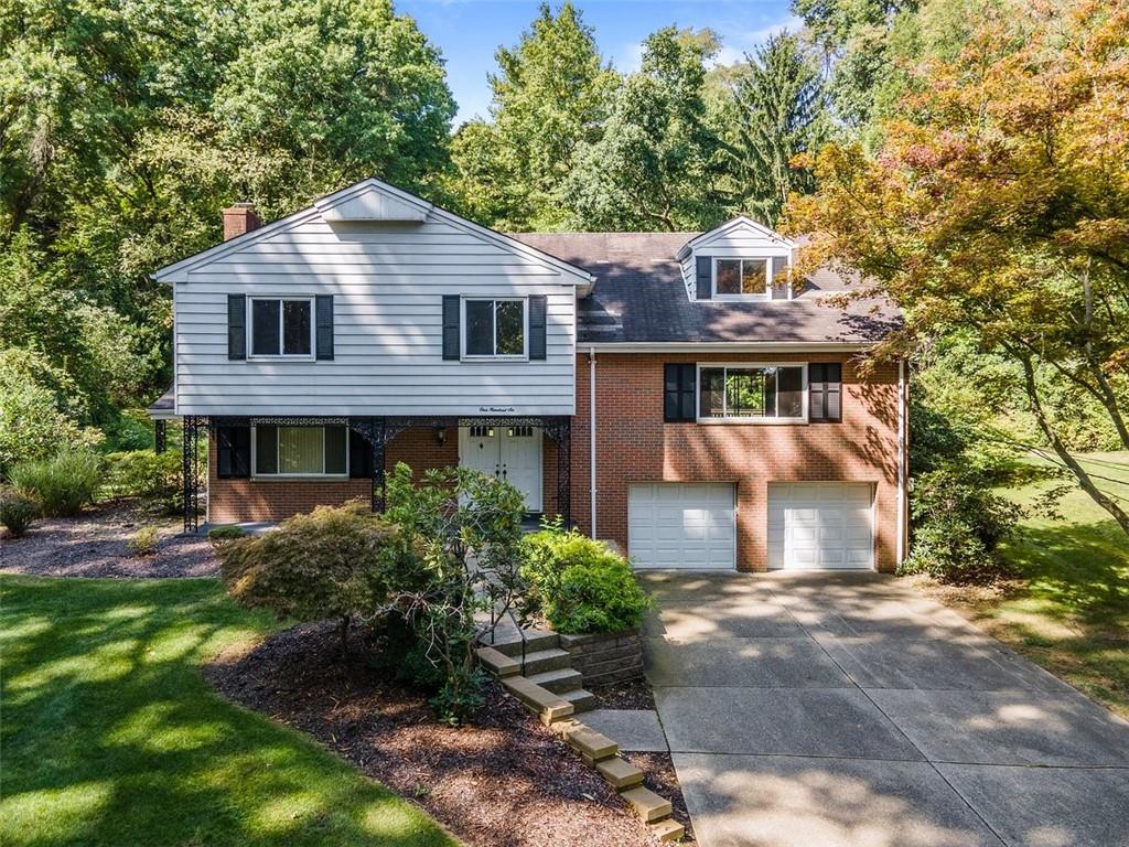 a front view of a house with a yard and trees