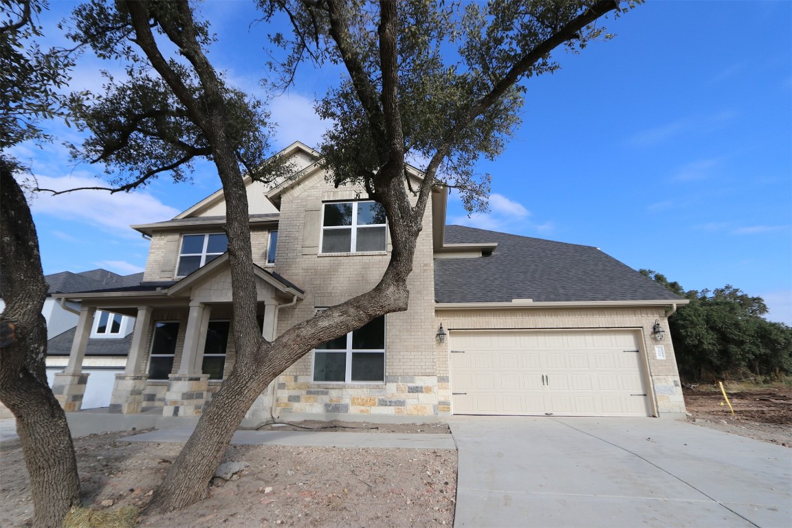 a front view of a house with a tree