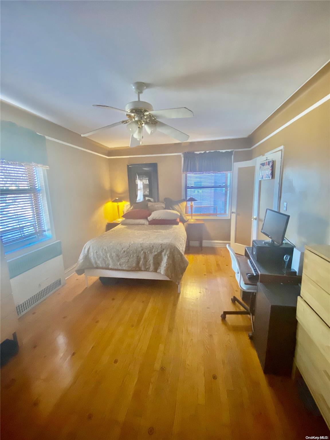 a spacious bedroom with a bed and wooden floor