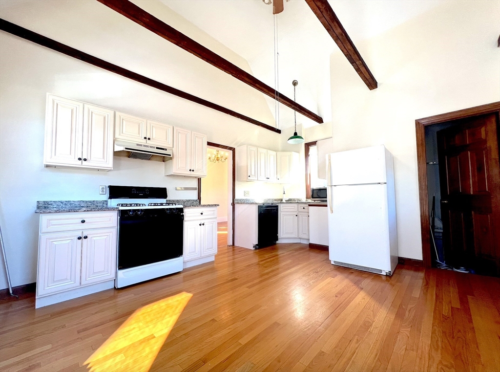 a kitchen with a refrigerator and a stove top oven