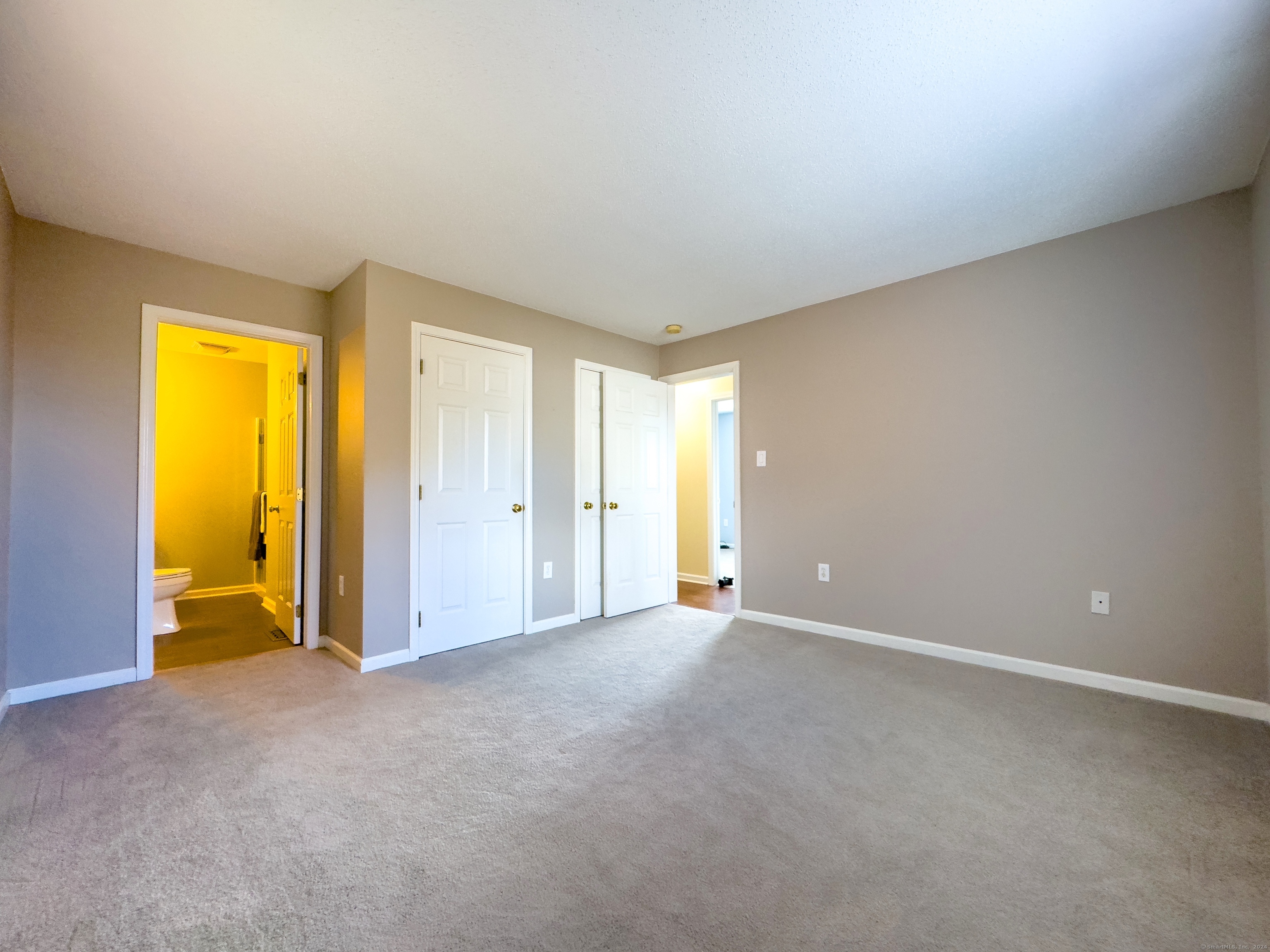 an empty room with a window and bathroom view