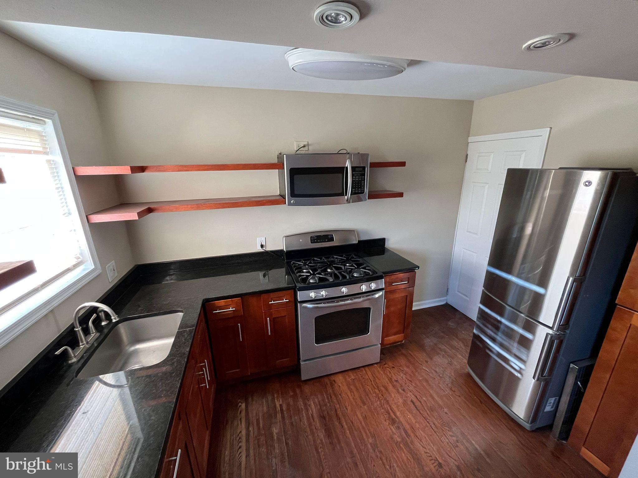 a kitchen with wooden floor and stainless steel appliances