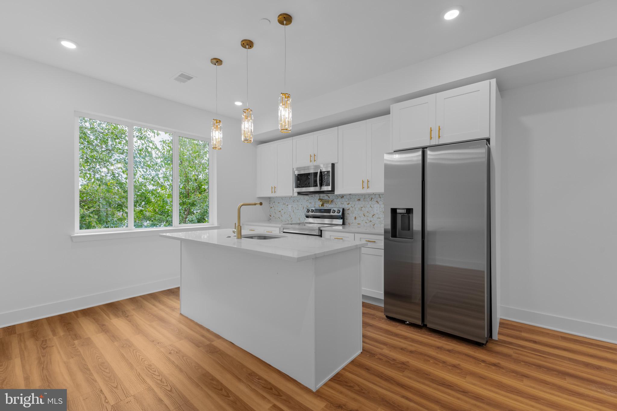 a kitchen with stainless steel appliances granite countertop a refrigerator and a stove top oven