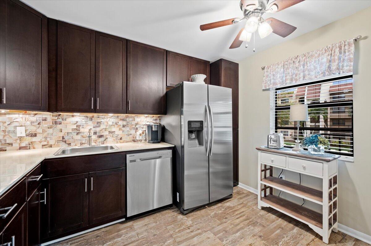 a kitchen with stainless steel appliances kitchen island granite countertop a refrigerator and a stove top oven