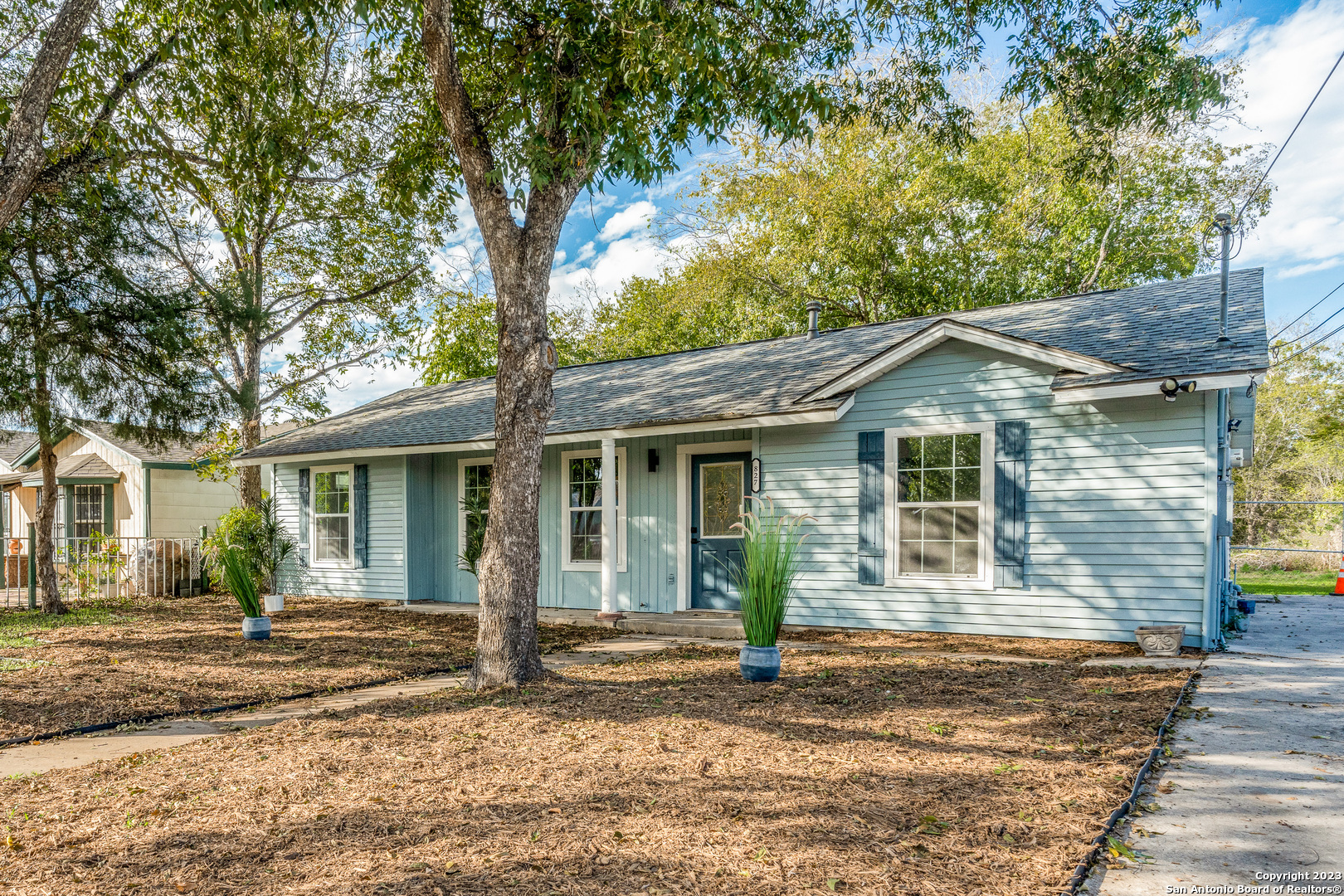 a front view of a house with a tree